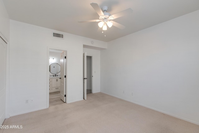 unfurnished bedroom featuring light carpet, baseboards, visible vents, and ensuite bathroom