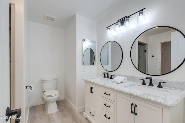 full bath with toilet, wood finished floors, a sink, and visible vents