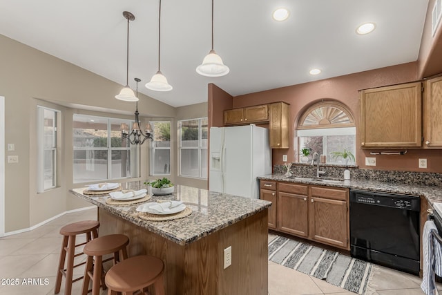 kitchen featuring white refrigerator with ice dispenser, dishwasher, lofted ceiling, stone counters, and a sink