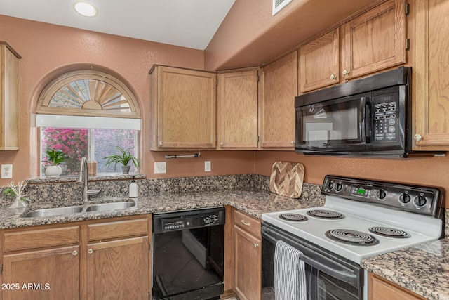 kitchen featuring black appliances, stone countertops, a sink, and a textured wall