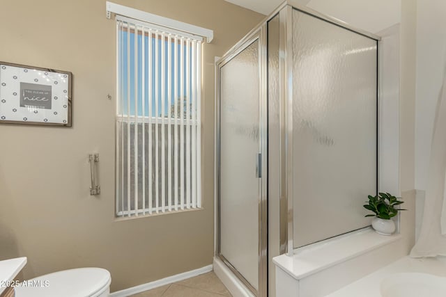 bathroom featuring toilet, vanity, baseboards, tile patterned floors, and a stall shower