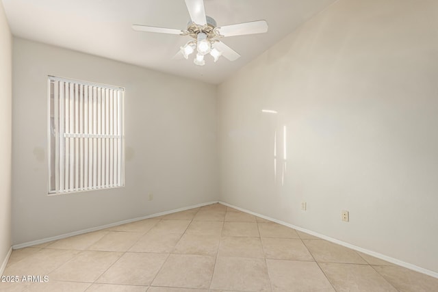 tiled spare room featuring a ceiling fan and baseboards