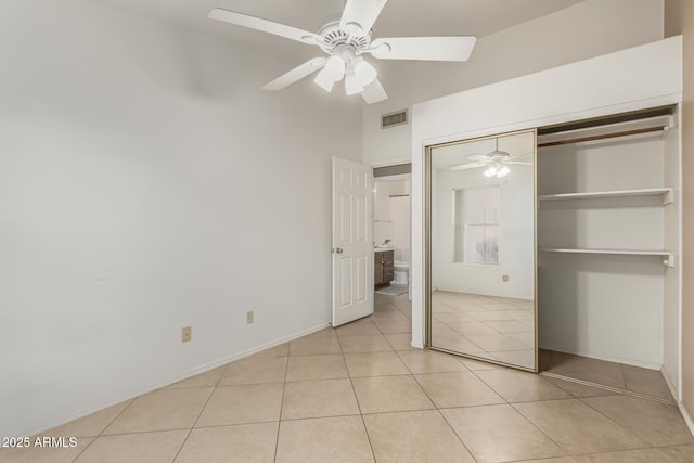 unfurnished bedroom with light tile patterned floors, a closet, visible vents, ceiling fan, and baseboards