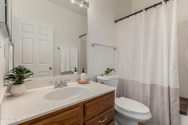 bathroom featuring curtained shower, vanity, and toilet