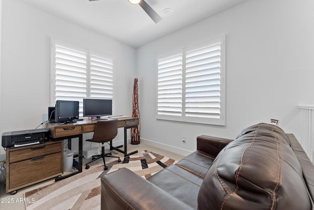 office area with ceiling fan, light carpet, and baseboards