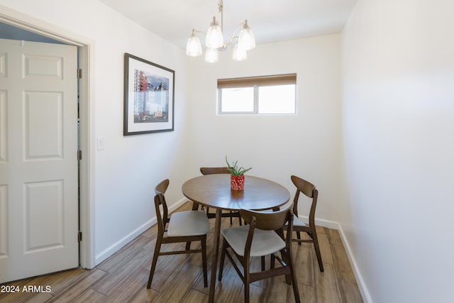 dining space featuring hardwood / wood-style floors and an inviting chandelier