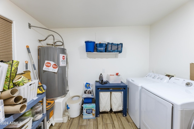 laundry area with electric water heater, light hardwood / wood-style flooring, and washer and clothes dryer