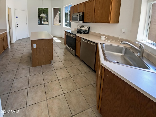 kitchen featuring plenty of natural light, stainless steel appliances, sink, and a kitchen island