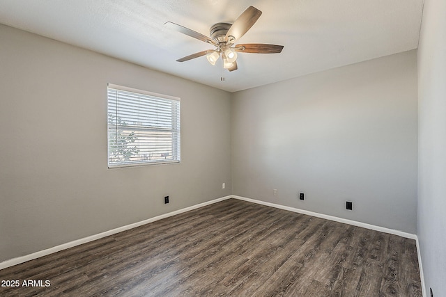empty room with dark wood-type flooring, a ceiling fan, and baseboards