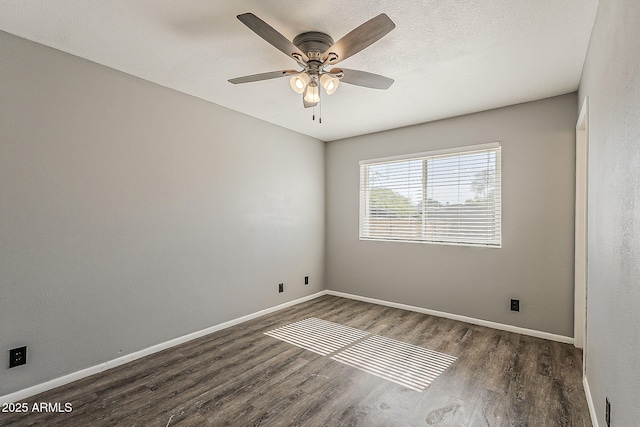 spare room featuring wood finished floors, baseboards, and a ceiling fan
