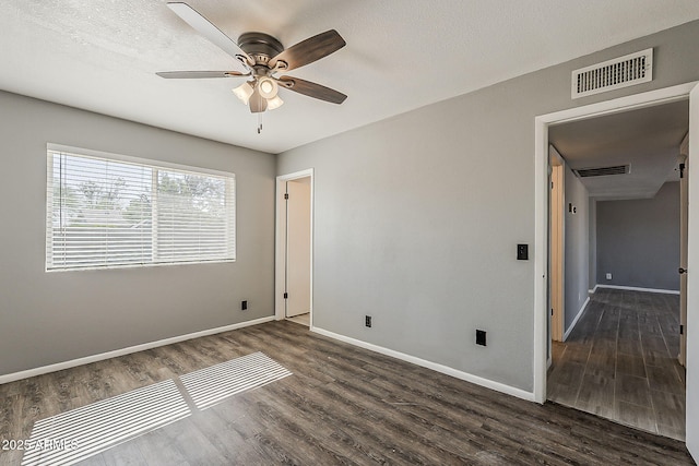 unfurnished bedroom with dark wood finished floors, baseboards, and ceiling fan