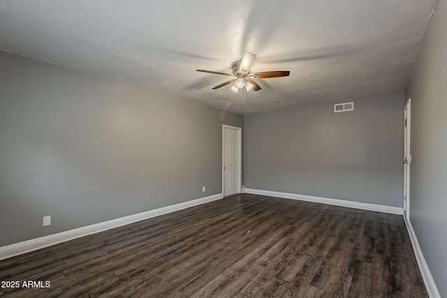 spare room with dark wood-style flooring, a ceiling fan, and baseboards