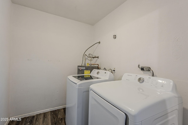 washroom featuring water heater, independent washer and dryer, dark wood-style flooring, and baseboards