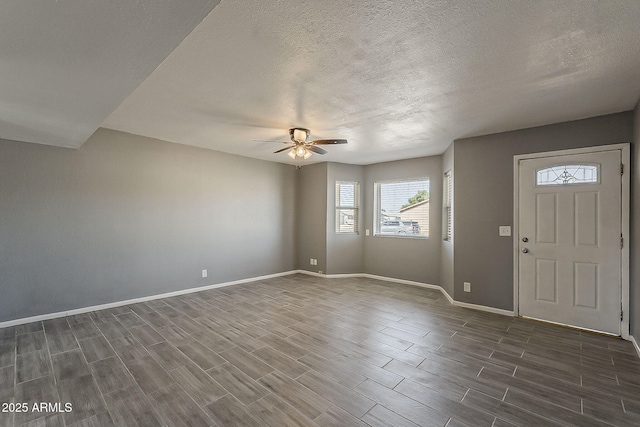 entrance foyer featuring a ceiling fan, wood tiled floors, baseboards, and a textured ceiling