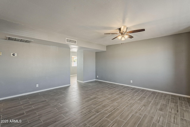 unfurnished room with ceiling fan, dark wood finished floors, and baseboards
