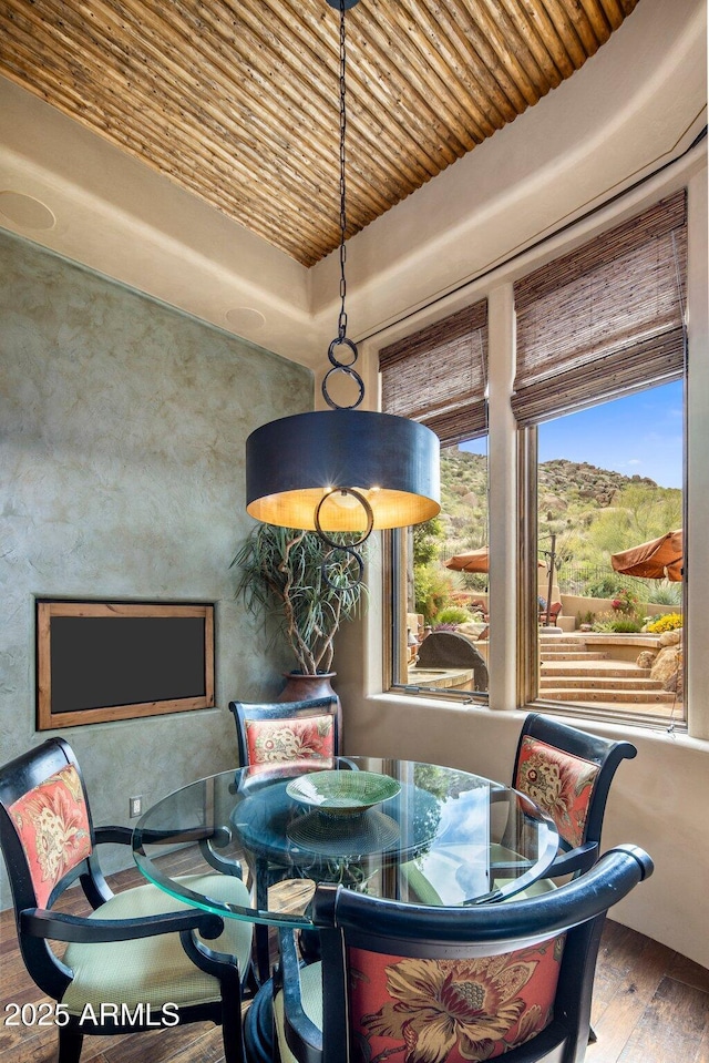 dining space featuring a tray ceiling, hardwood / wood-style floors, and wood ceiling