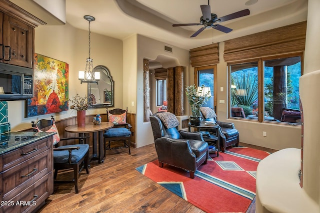 interior space featuring a raised ceiling, ceiling fan, and light hardwood / wood-style flooring