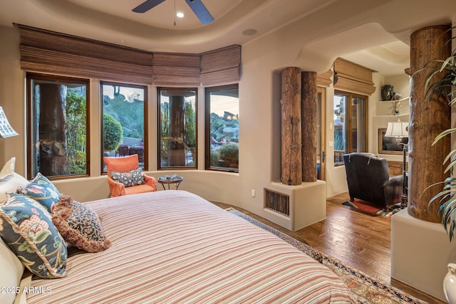 bedroom with hardwood / wood-style flooring and multiple windows