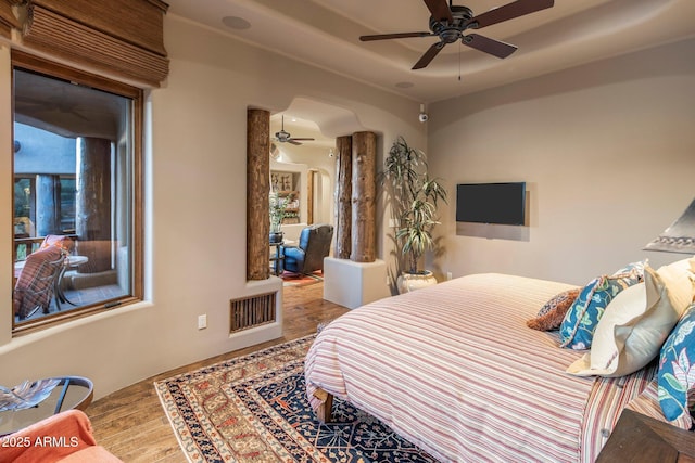 bedroom featuring a raised ceiling and wood-type flooring