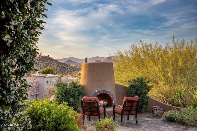 view of patio / terrace featuring an outdoor fireplace and a mountain view