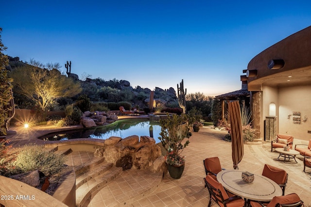 pool at dusk with a patio