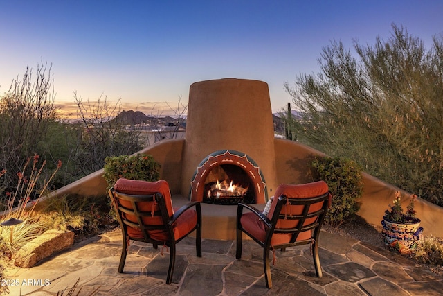 patio terrace at dusk with an outdoor brick fireplace