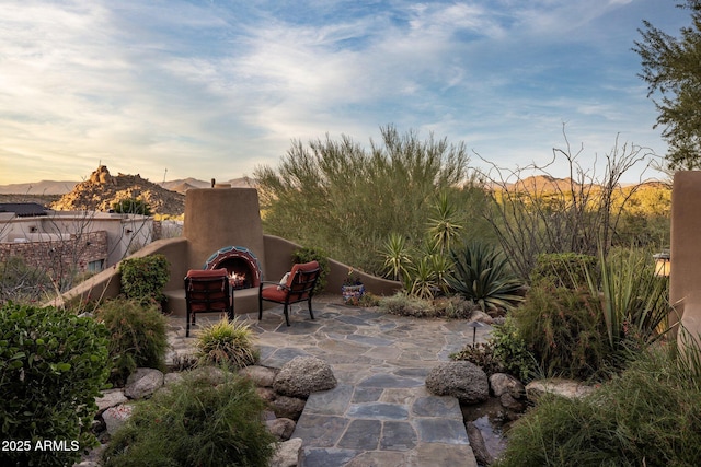 patio terrace at dusk with an outdoor fireplace