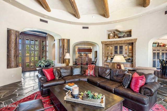 living room featuring beamed ceiling and a towering ceiling