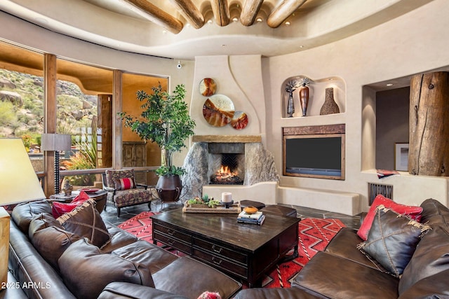 living room with beam ceiling and a large fireplace