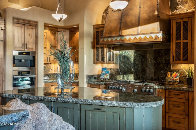 kitchen featuring stainless steel double oven, dark stone countertops, range, and backsplash