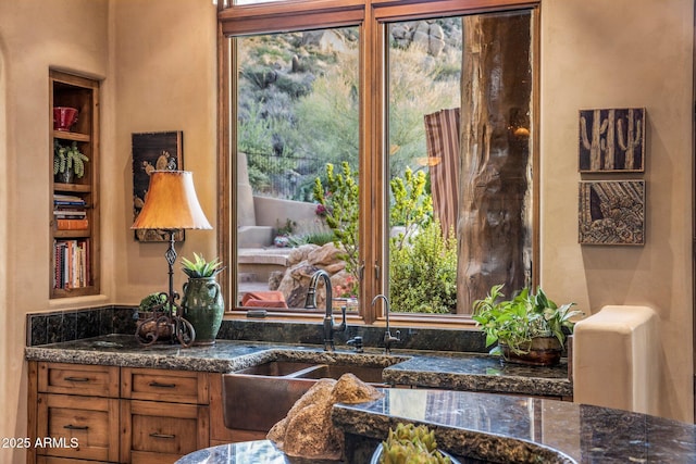 interior space with sink and dark stone counters