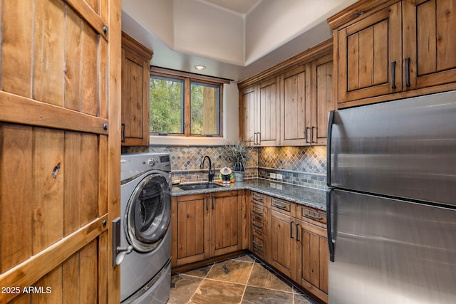 washroom with sink, washer / dryer, and cabinets