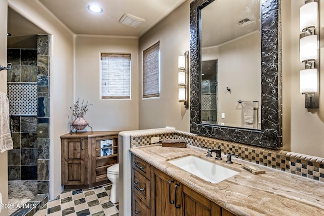 bathroom with vanity, decorative backsplash, toilet, and tiled shower