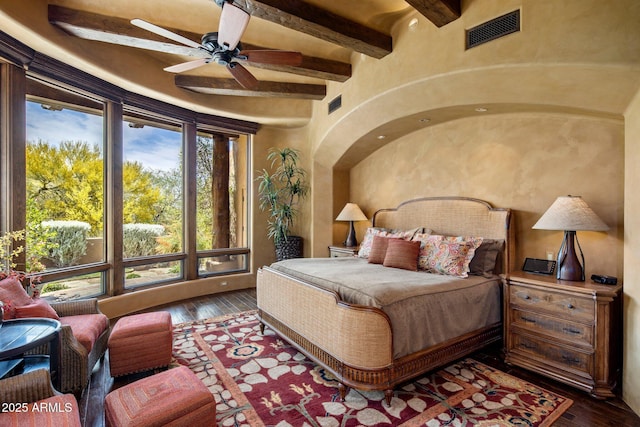 bedroom featuring dark hardwood / wood-style flooring and beam ceiling