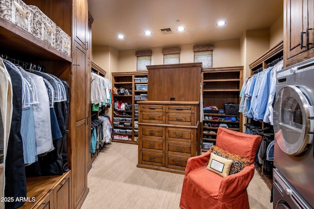 walk in closet featuring light colored carpet and stacked washer / drying machine