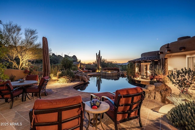 pool at dusk with a patio area