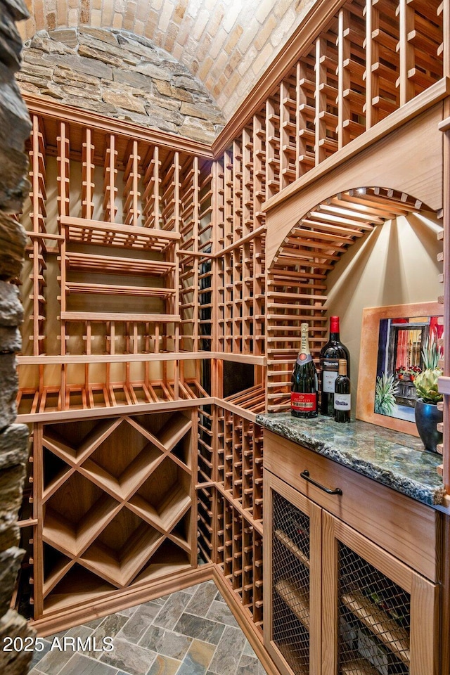 wine area with brick ceiling and vaulted ceiling