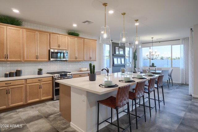 kitchen featuring light brown cabinetry, an island with sink, and appliances with stainless steel finishes