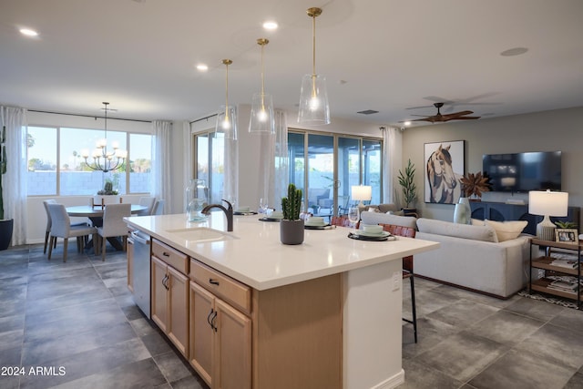 kitchen featuring dishwasher, sink, an island with sink, pendant lighting, and light brown cabinetry