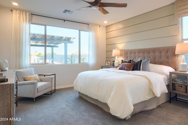 bedroom with multiple windows, ceiling fan, and carpet floors