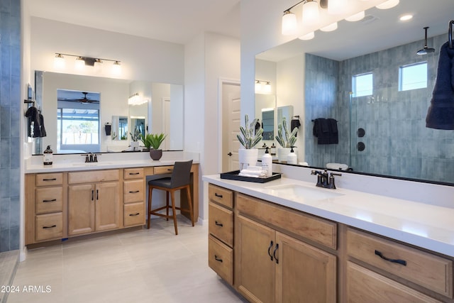 bathroom with a tile shower, tile patterned flooring, and vanity