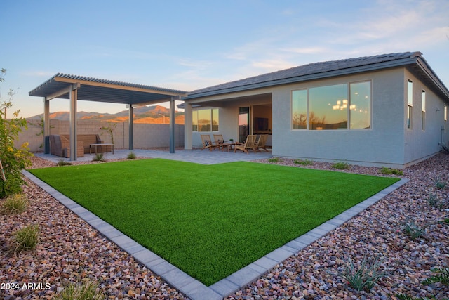 rear view of property featuring a pergola, a yard, and a patio area