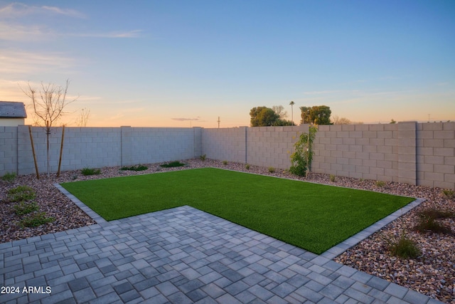 yard at dusk with a patio area