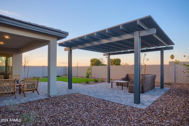 patio terrace at dusk with a pergola and outdoor lounge area