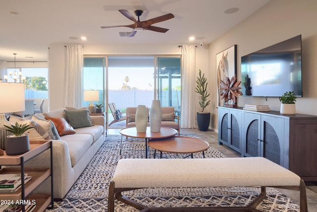 living room with plenty of natural light and ceiling fan with notable chandelier