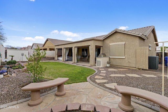 rear view of property with a lawn, a patio, a fenced backyard, a tile roof, and stucco siding