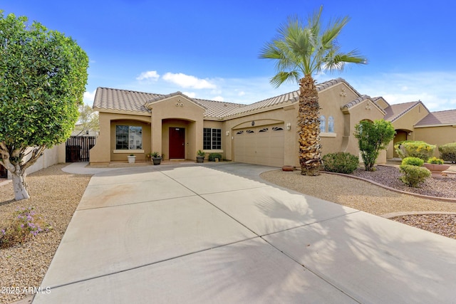 mediterranean / spanish-style house featuring a garage, fence, a tile roof, concrete driveway, and stucco siding