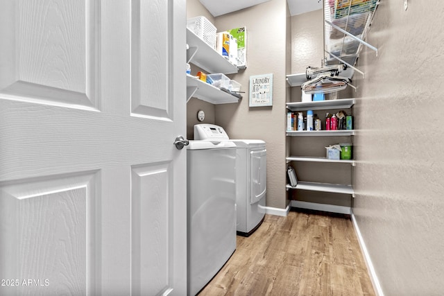 washroom featuring wood finished floors, laundry area, baseboards, and separate washer and dryer