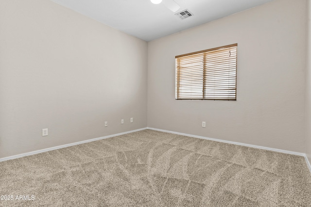 empty room featuring carpet floors, baseboards, and visible vents