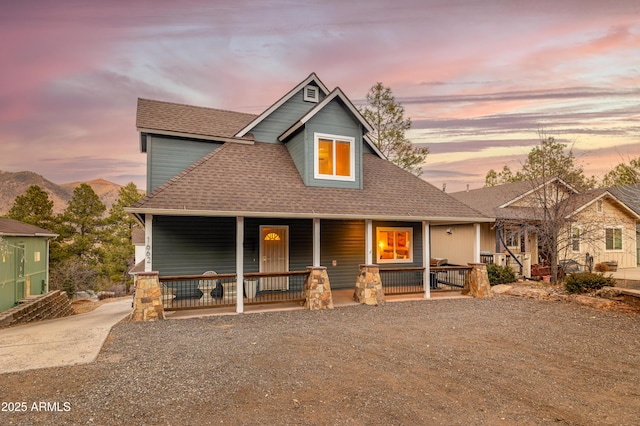 view of front of house with covered porch and a shingled roof